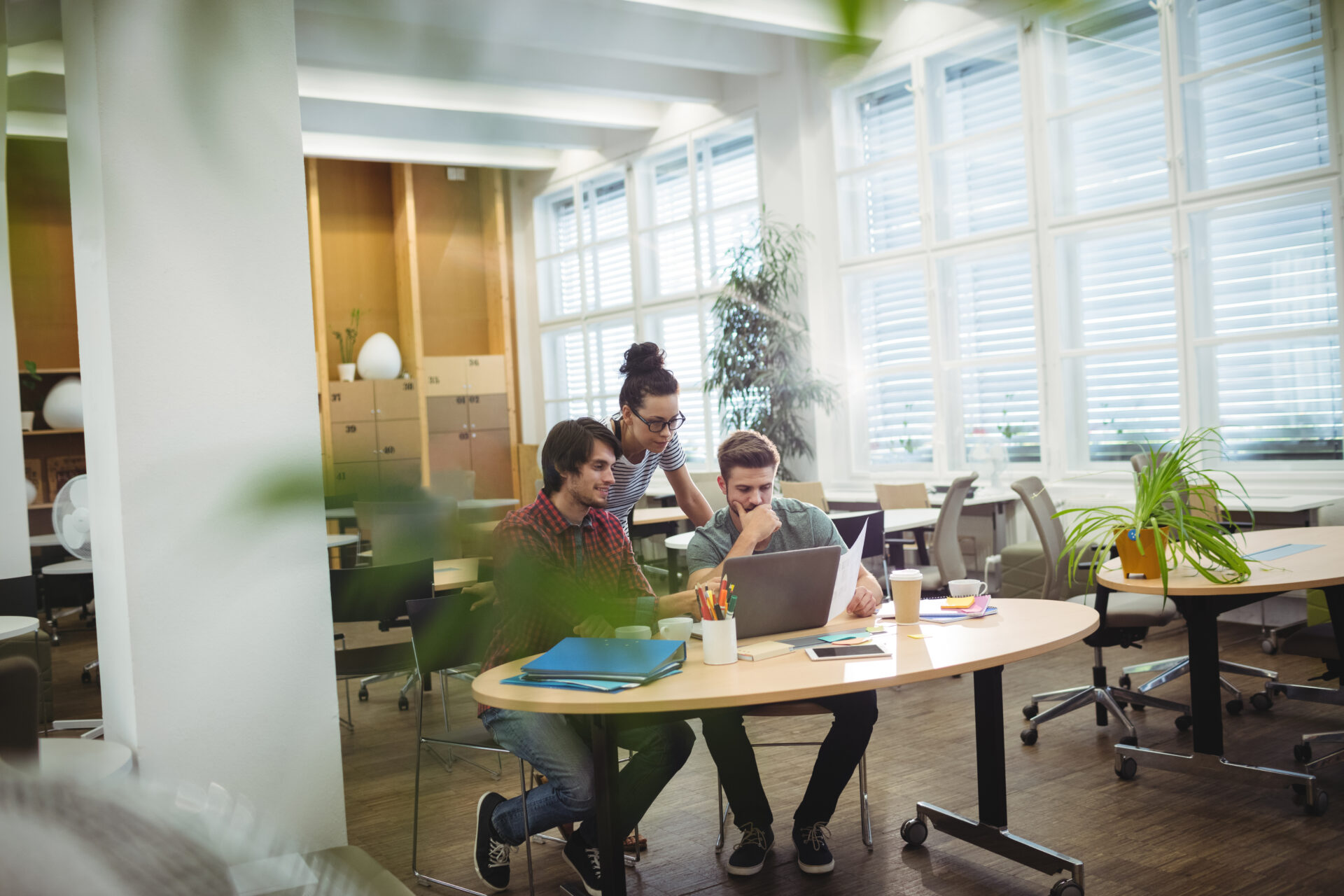 Group of business executives discussing over laptop at their desk in the office