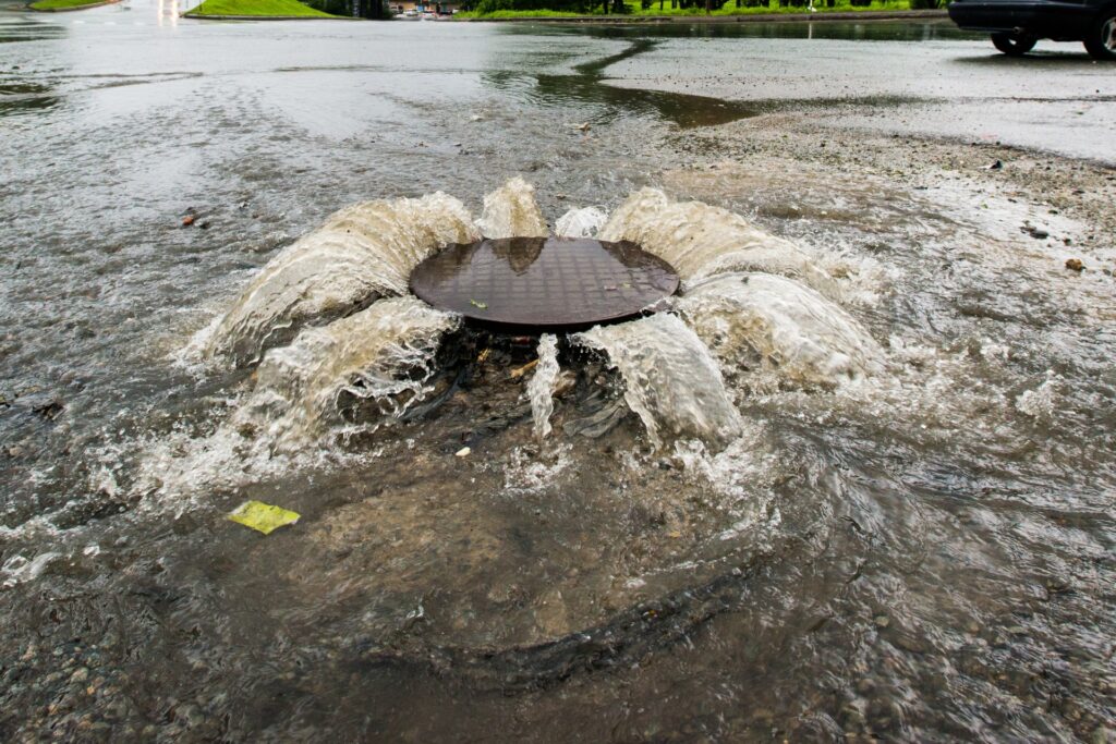 Accident sewerage system. Water flows over the road from the sewer.