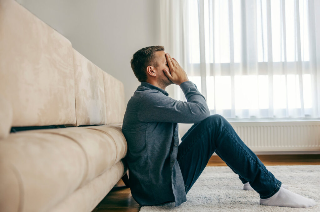 A depressed man is stressed and sad while sitting on the floor at home.; Shutterstock ID 2394515497; purchase_order: Allatjoleti_konferencia_001; job: ; client: ; other: